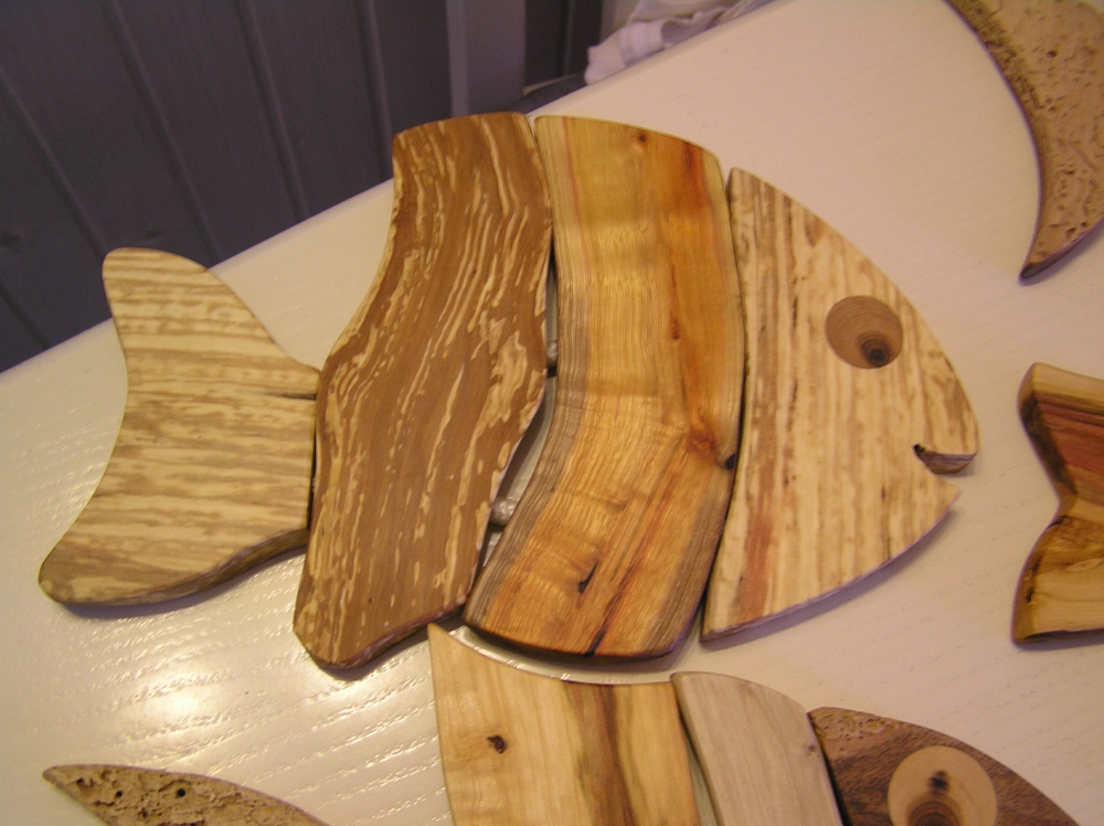 Iz lesa oblikovan podstavek za posodo. Njegova igrivost v obliki ribe bo dala namiznemu pogrinjku še dodaten čar.